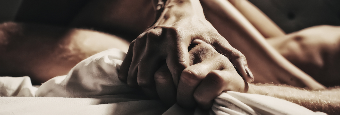 couple holding hands in bed